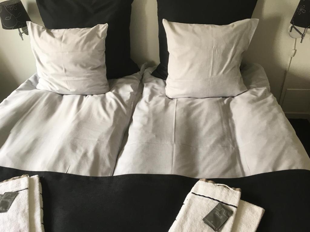 RøddingHotel Rødding的一张带白色床单和枕头的床