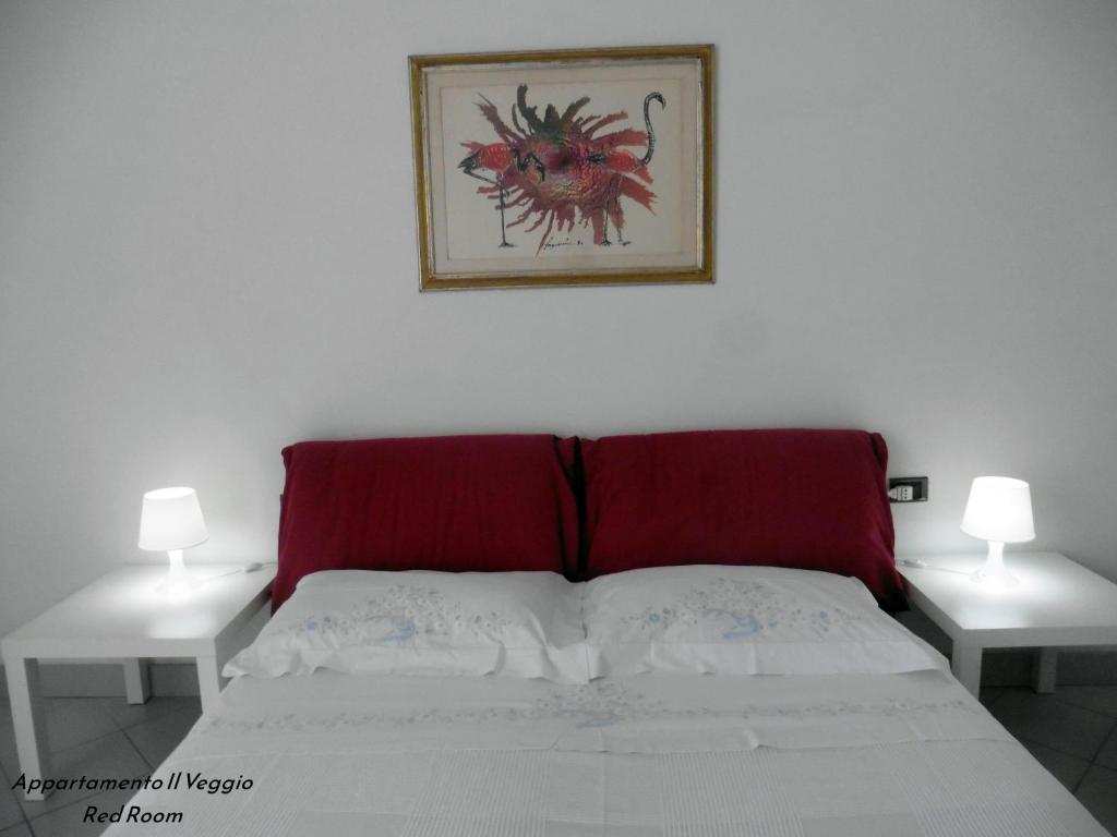 波焦阿卡伊阿诺Appartamento il Veggio的卧室里一张红色床头的床