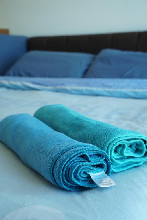 史里肯邦安2 Carpark GEP 5 Star Hotel Bed & Sofa Studio的床上的蓝色滚动毛巾