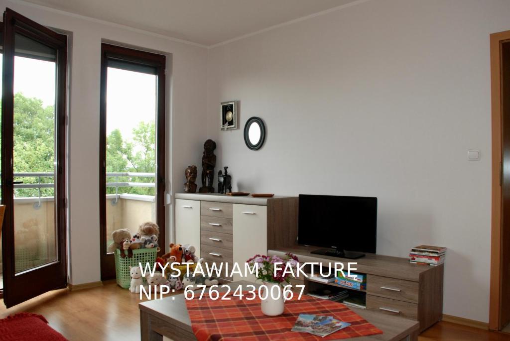 克拉科夫Apartment AMUR的客厅配有电视和桌子