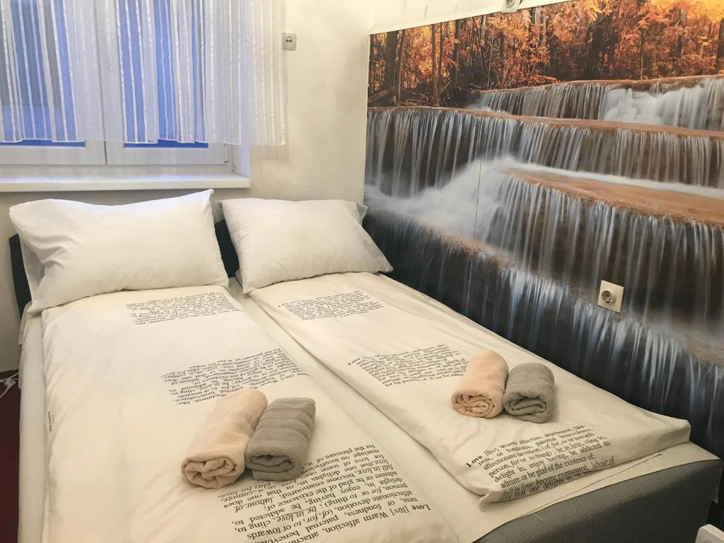 萨拉热窝Sarajevo Rooms的客房内的两张床和毛巾