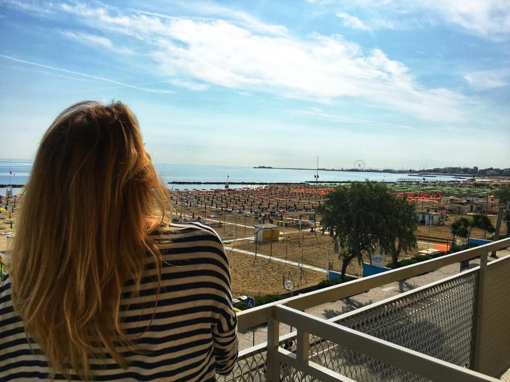 里米尼Hotel Tritone Rimini的坐在城市阳台上的女人