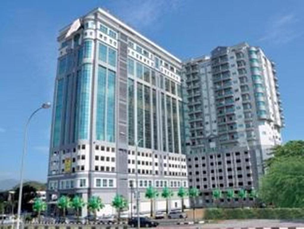 怡保丽晶塔公寓式酒店的两座高大的建筑,前面有棕榈树
