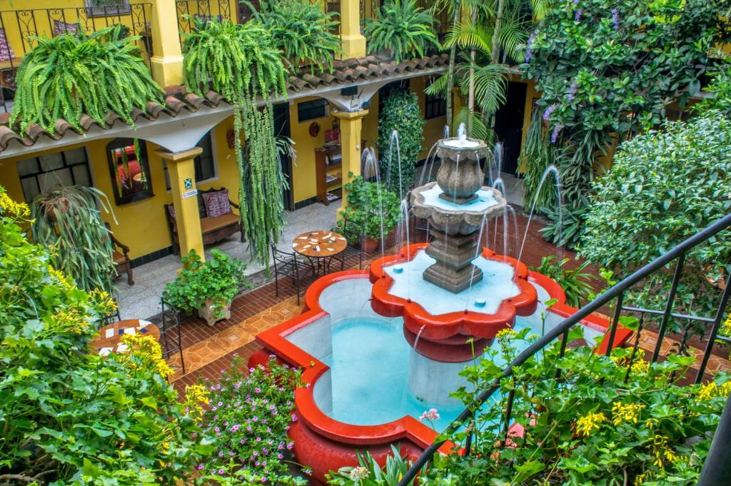 危地马拉安地瓜Posada San Vicente by AHS的一座花园,在一座建筑的中间有一个喷泉