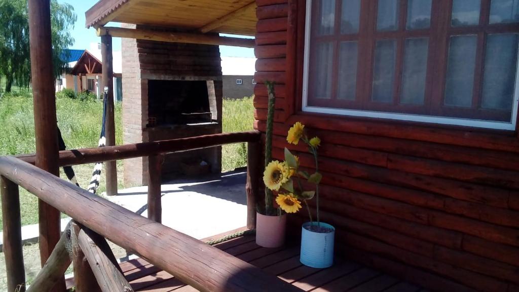 巴里尼奥Las Huellas Cabaña的小木屋的门廊设有壁炉