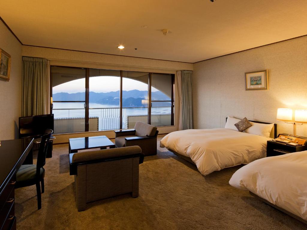 南淡路市广场淡路岛酒店的酒店客房设有两张床和大窗户。
