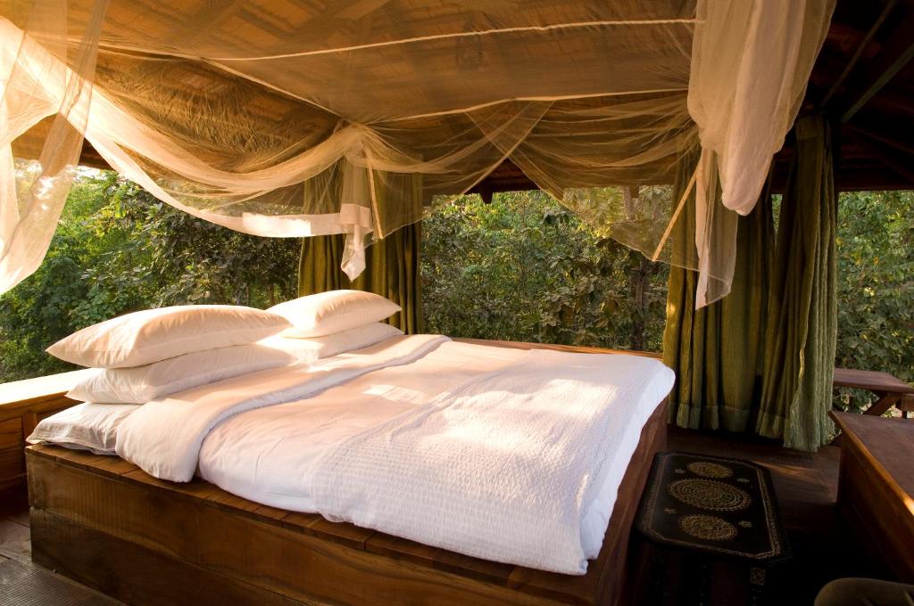 BehraiBaghvan Pench National Park - A Taj Safari Lodge的卧室在窗户前配有一张床