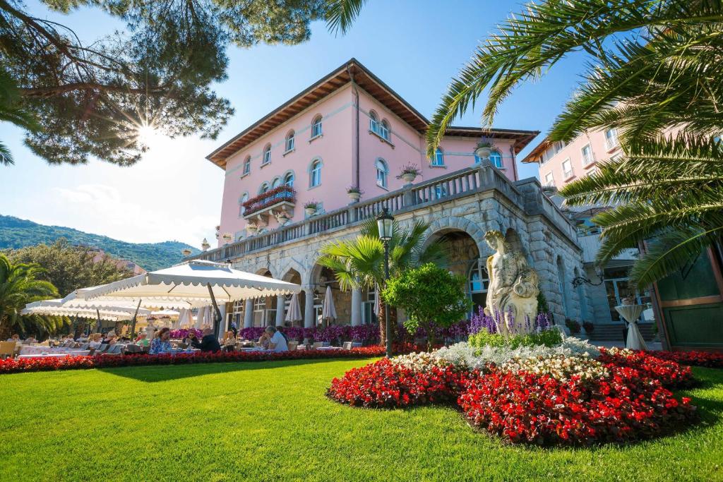 奥帕提亚阿玛迪利亚公园米勒尼酒店的一座粉红色的大建筑,前面有鲜花