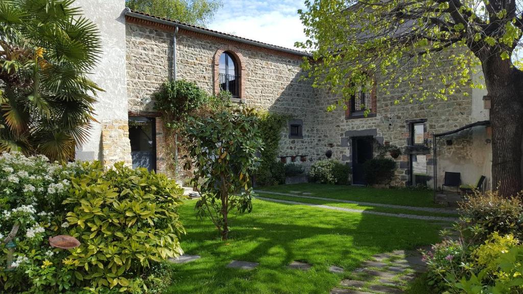 奥弗涅库尔农Altamica的一座带绿色庭院的古老石头房子