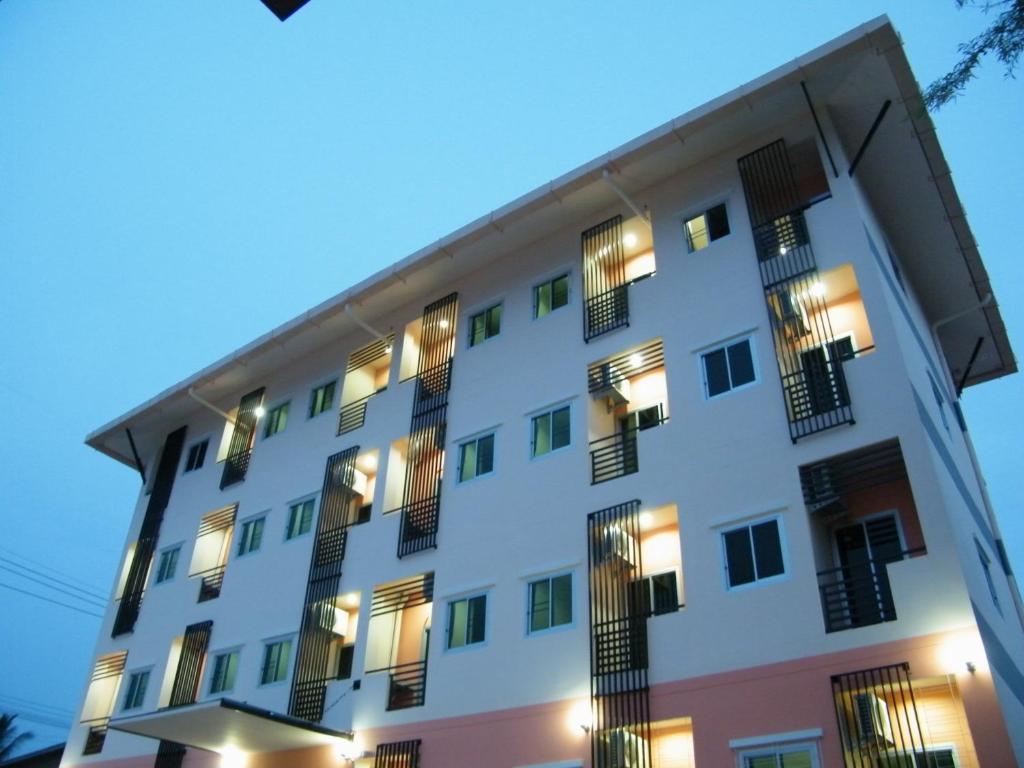乌汶房迪1号大厦酒店的一座白色的大建筑,晚上有窗户
