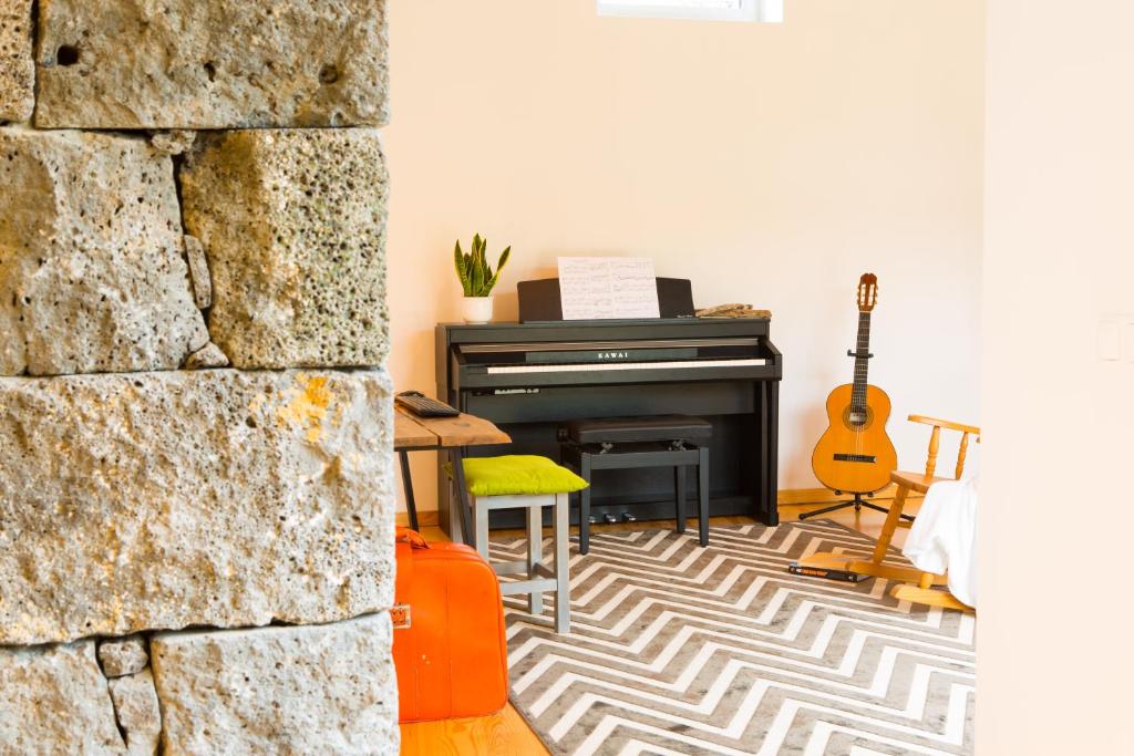 拉日什杜皮库Casa dos Caldeiras的客厅配有钢琴和吉他