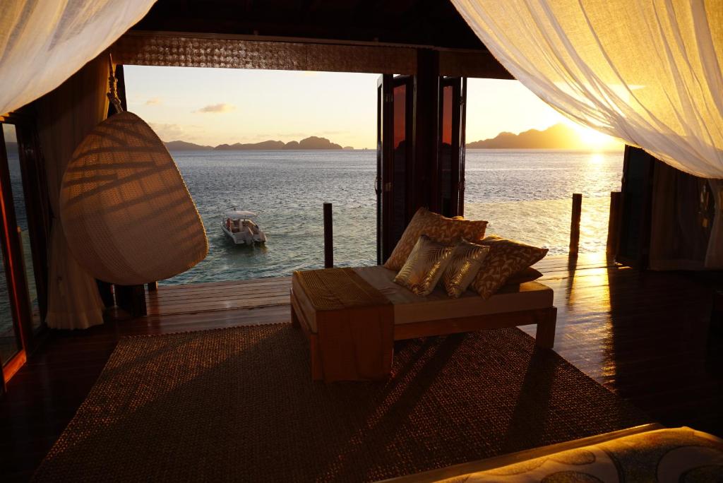 爱妮岛维拉戈度假酒店的一间配有沙发并享有水景的客房