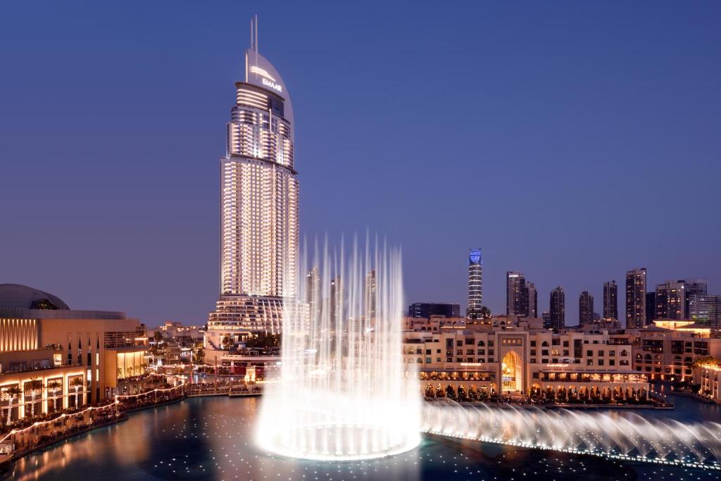 迪拜迪拜市中心地标酒店的一座高大的建筑,在城市前方有一个喷泉