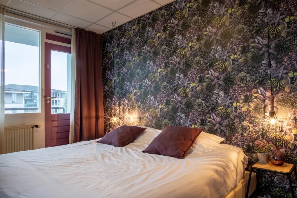 希勒霍姆弗洛拉别墅酒店的一间卧室配有一张带花卉壁纸的床