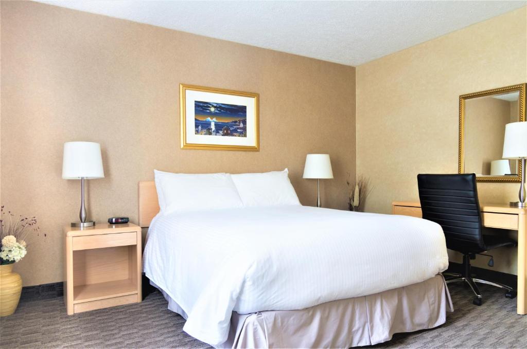 温莎大瀑布Mount Peyton Resort & Conference Centre的酒店客房设有一张大床和一张书桌。