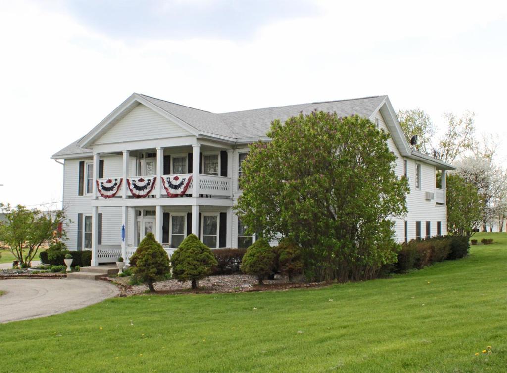 加利纳Belle Aire Mansion Guest House的白色的房子,上面有美国国旗