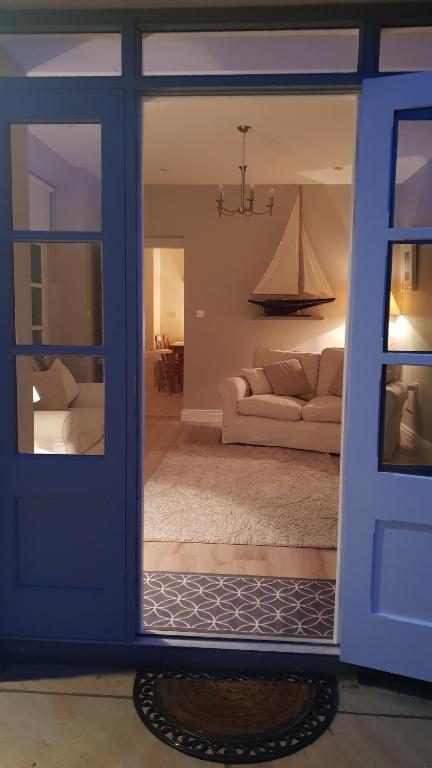 科克The Coach House Douglas的客厅设有蓝色的门和沙发