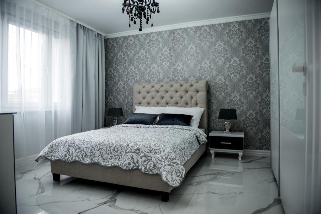 皮拉Glamour Apartments的一间卧室配有一张大床和一个吊灯。