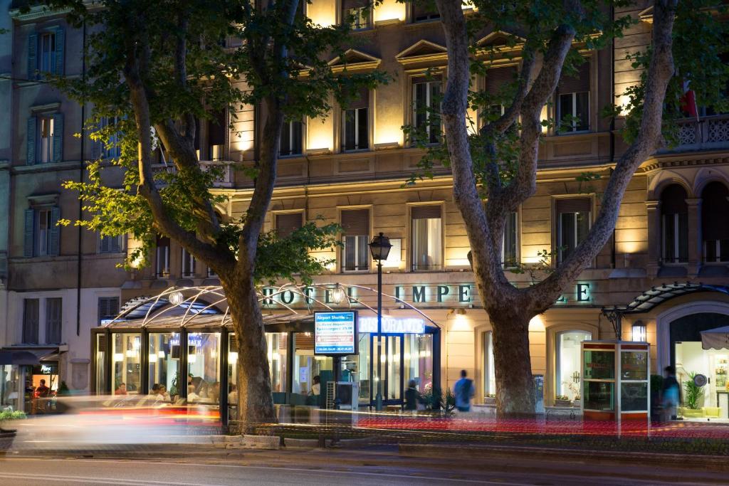 罗马Hotel Imperiale by OMNIA hotels的前方树木林立的街道上的建筑