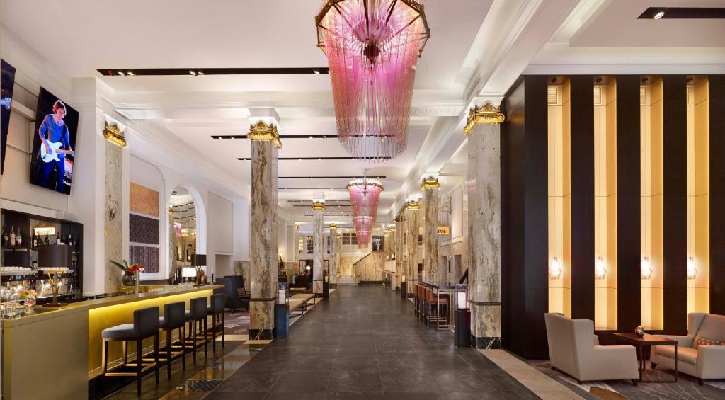 汉堡Reichshof Hotel Hamburg的大堂设有酒吧和粉红色吊灯