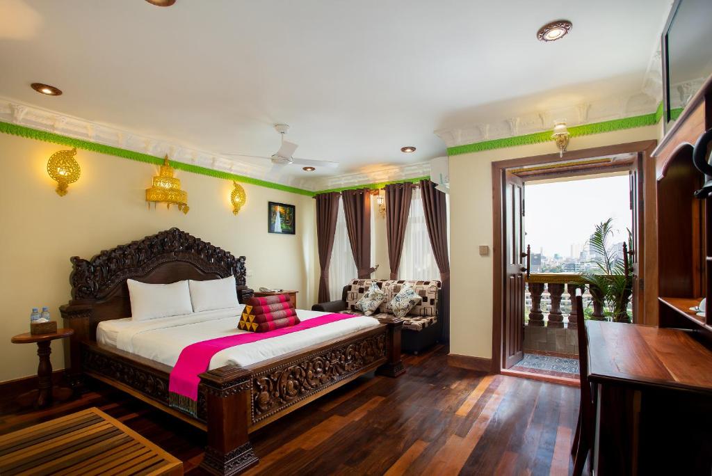 金边Okay Palace Hotel的一间卧室设有一张床和一间客厅。