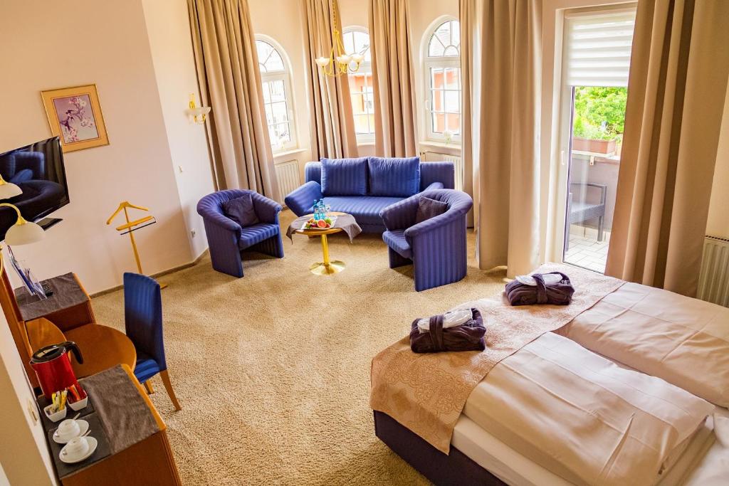 Löhnberg皇冠餐厅及酒店的一间卧室配有床和椅子,一间客厅