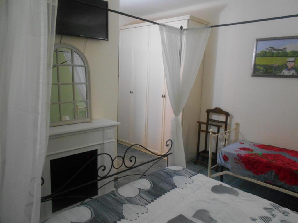阿西西Relais"LA CAPPUCCINA" Rooms&Apartments的客房设有壁炉、床和电视。