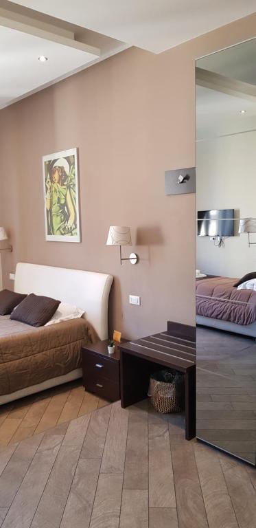 罗马米娅套房酒店的一间卧室配有两张床、一张桌子和一面镜子