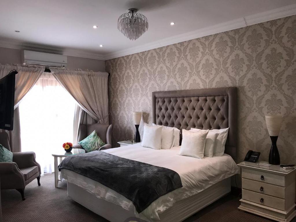 约翰内斯堡Classique Grace Boutique Hotel的一间卧室设有一张大床和一个窗户。