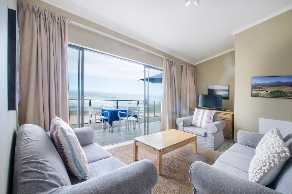 赫罗德斯湾Herolds Bay Accommodation - Hiers Ons Weer Upstairs的带沙发和椅子的客厅以及大窗户。