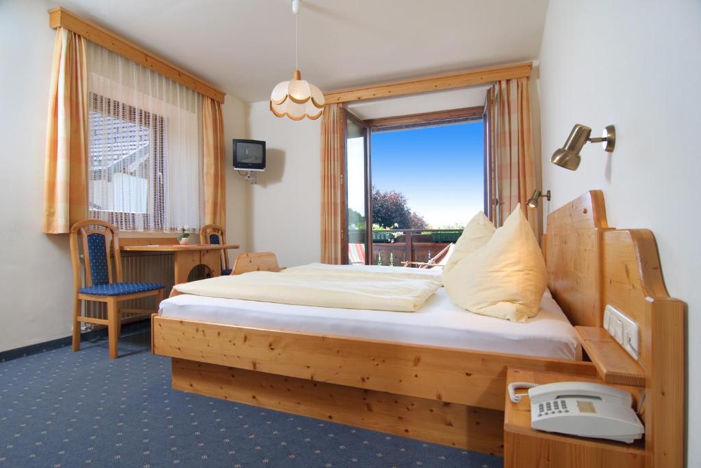 拉茨查赫·奥伯登弗胡伯托斯霍夫旅馆的一间卧室设有一张木床和一个窗户。
