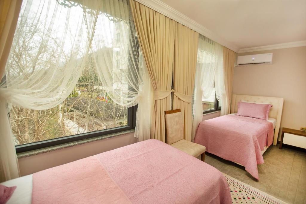 MackaJolnar garden hotel的一间卧室设有两张粉红色的床和窗户。