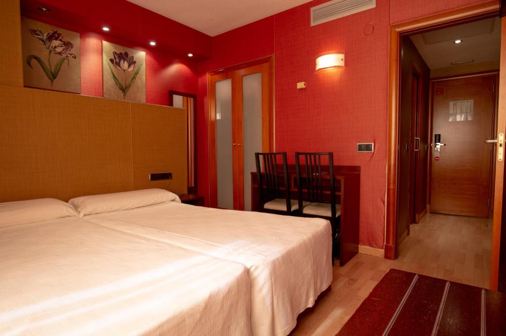 马德里维拉德巴拉哈斯酒店的卧室设有白色的床和红色的墙壁