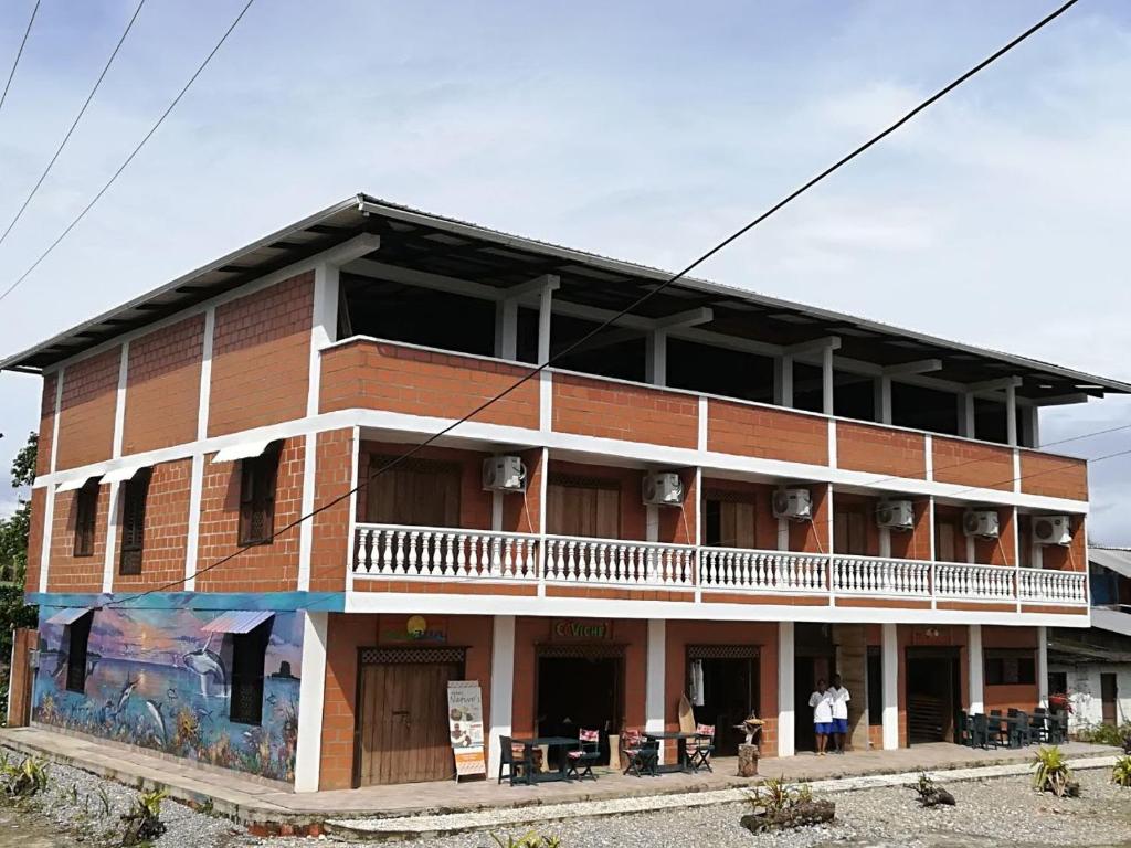 努基Hotel Acuali Nuqui的一面是一座大型砖砌建筑,设有阳台