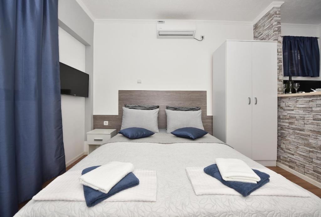 马卡尔斯卡Apartments Song of Joys的一间卧室配有一张带蓝白色枕头的大床