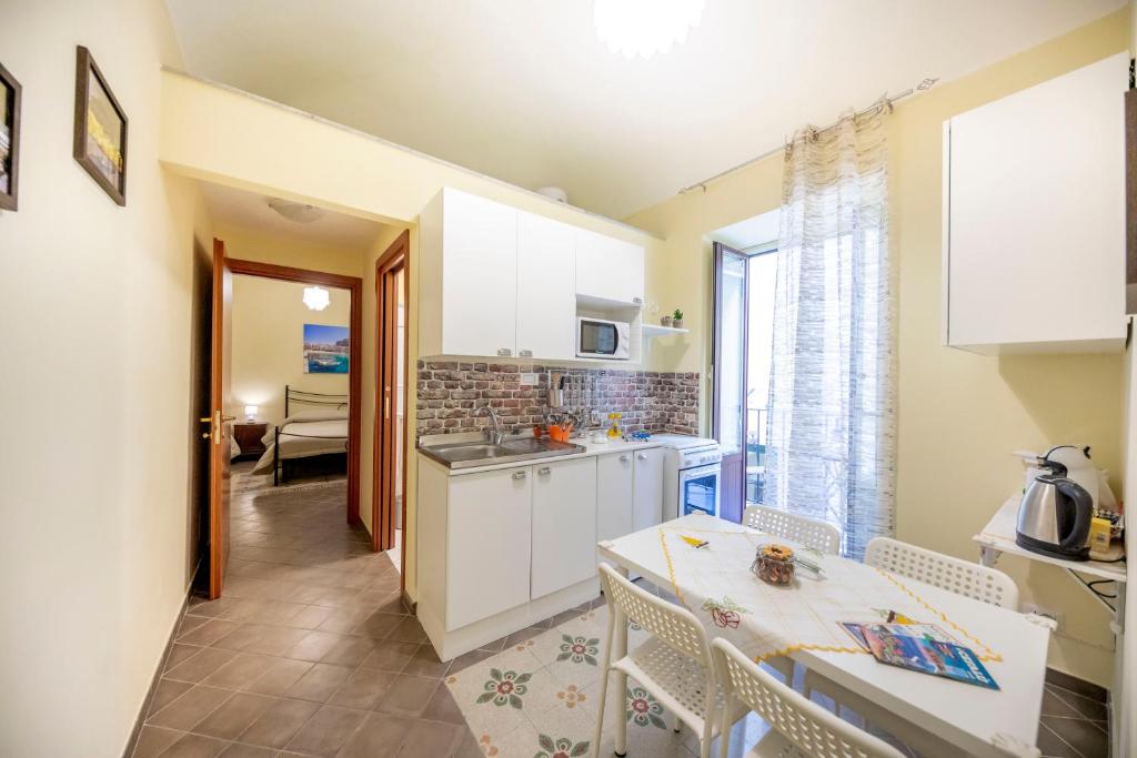切法卢Sicilian Dream Apartments的厨房配有白色橱柜和桌椅