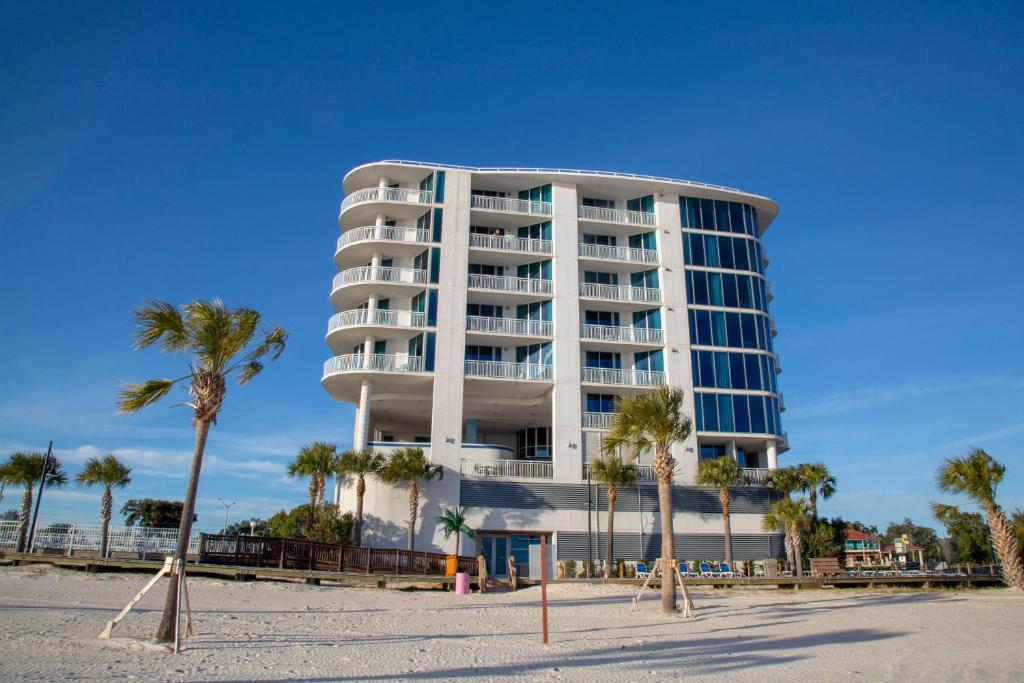 比洛克西南滩比洛克西酒店及套房的海滩上一座白色的大建筑,种有棕榈树