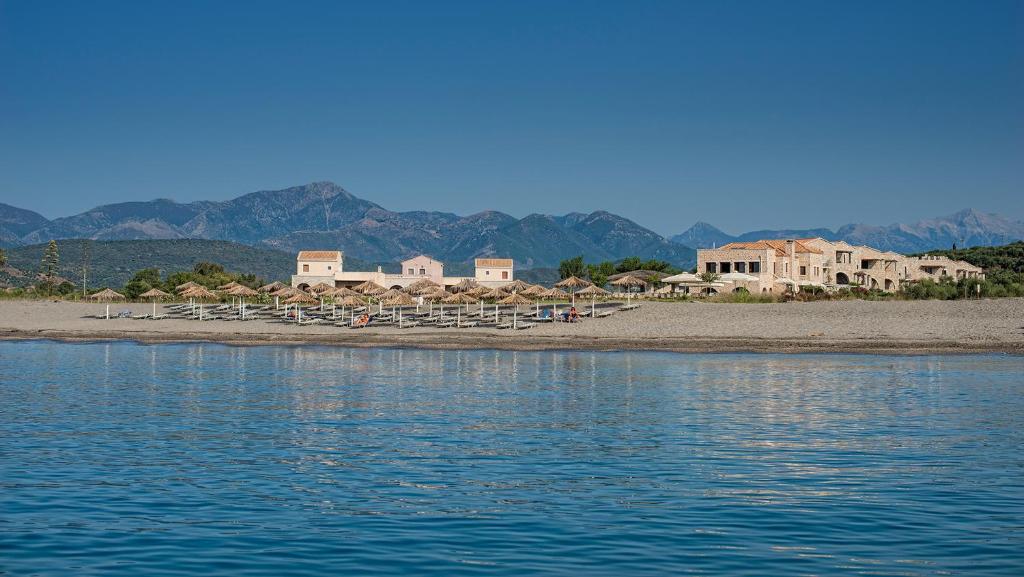 伊西翁Castello Antico Hotel的海岸边带椅子和遮阳伞的海滩