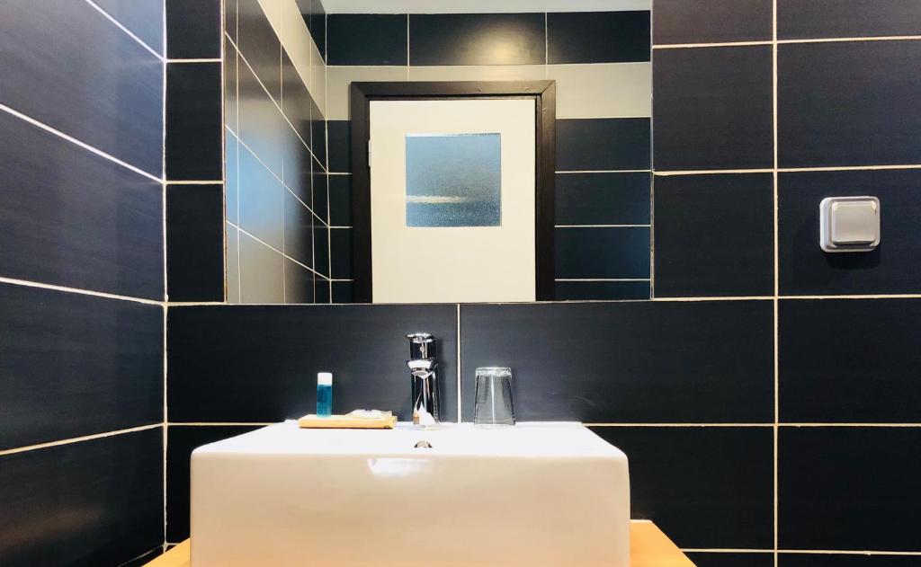 阿比让休闲酒店的浴室设有白色水槽和镜子