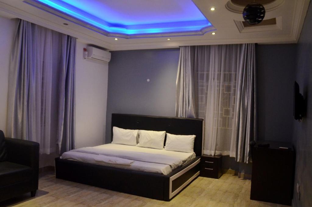阿布贾House X的一间卧室设有一张天花板上蓝色灯光的床。