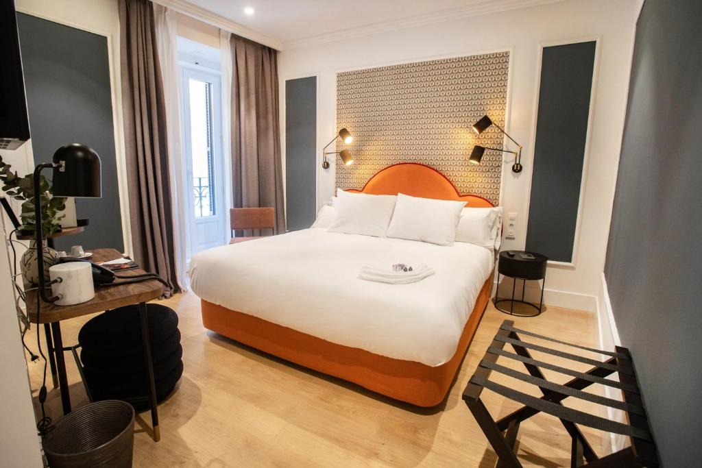 马德里Soho Boutique Opera的酒店客房带一张大床,带白色床单
