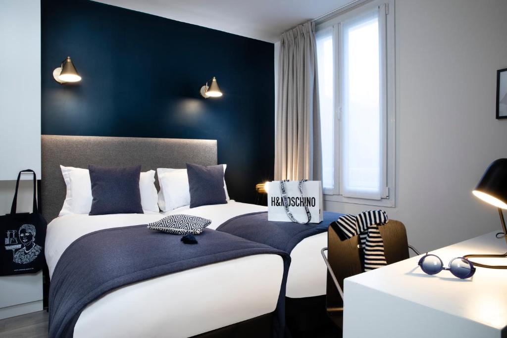 巴黎布雷迪酒店 - 巴黎火车东站的一间卧室设有两张床和蓝色的墙壁