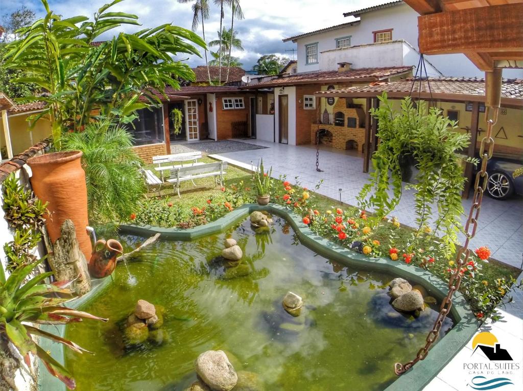 帕拉蒂Portal Sui­tes Casa do Lago的花园内设有带滑梯的池塘