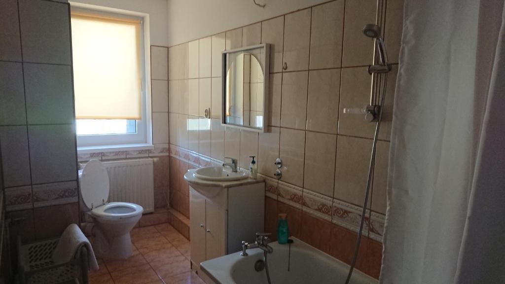 什切青Grzyminska的浴室配有卫生间、盥洗盆和浴缸。
