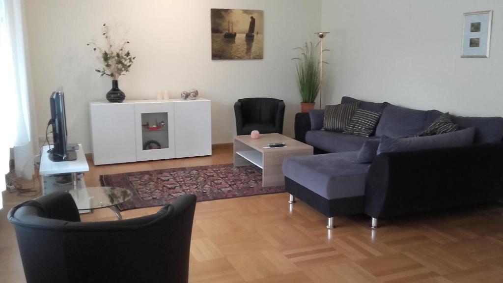 赖讷Ferienwohnung Bea in Rheine的客厅配有沙发、椅子和电视
