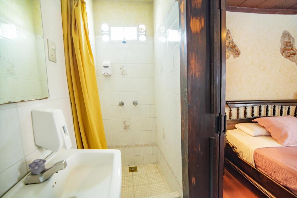 危地马拉安地瓜La Quinta Santa Lucia的一间带水槽和淋浴的浴室以及一张床