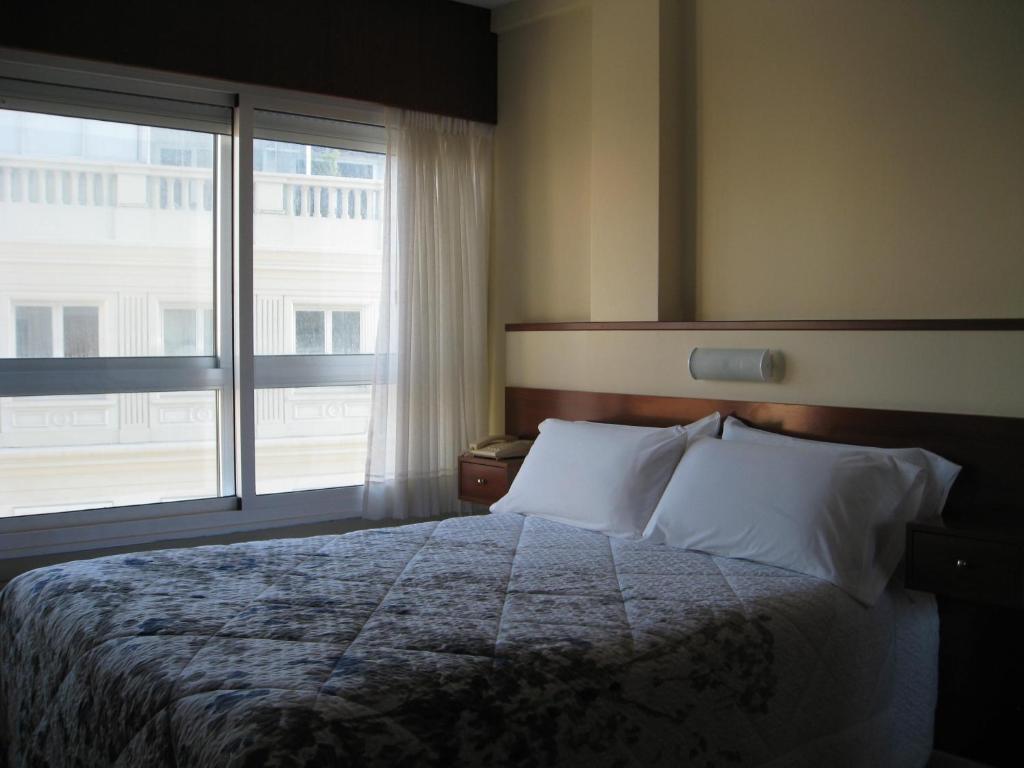 拉科鲁尼亚罗马旅馆的一间卧室设有一张大床和大窗户