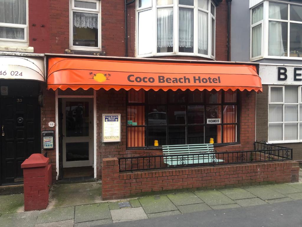 布莱克浦Coco Beach Hotel的大楼内有橙色遮阳篷的餐厅