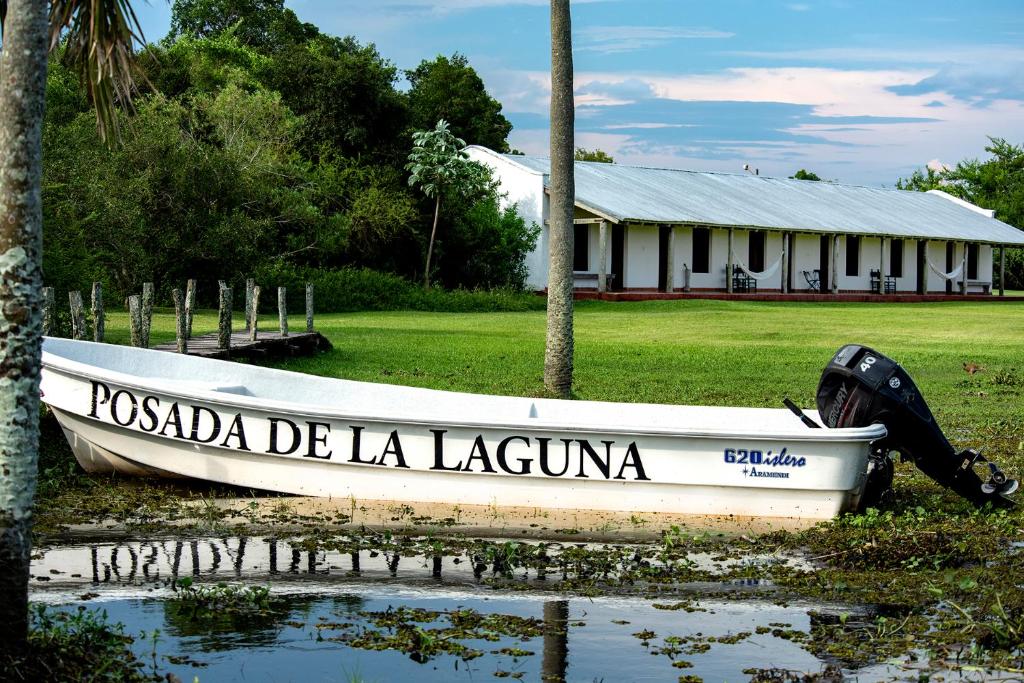 科洛尼亚卡洛斯佩莱格里尼Posada de la Laguna的坐在建筑物前的水面上的船