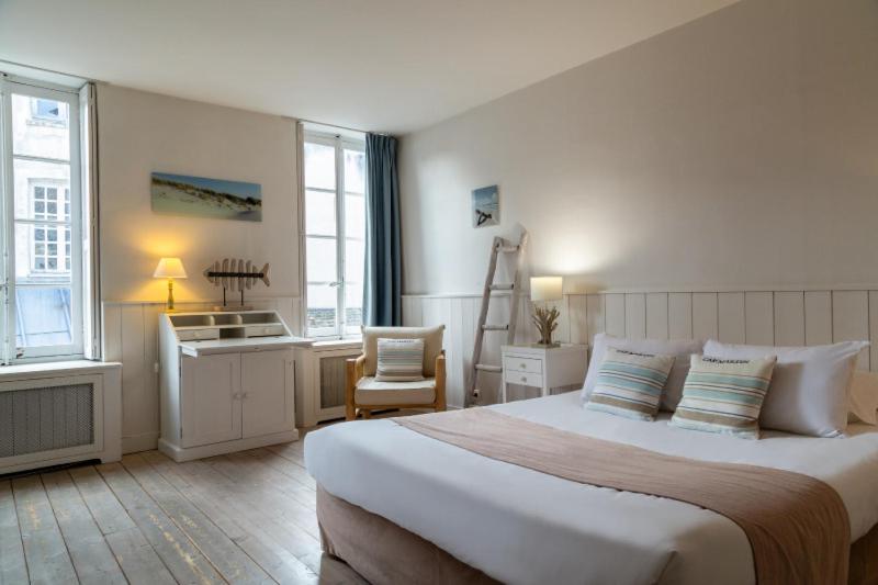 蒙福尔拉莫里Hôtel Saint-Laurent, The Originals Relais的酒店客房设有一张大床和一张书桌。